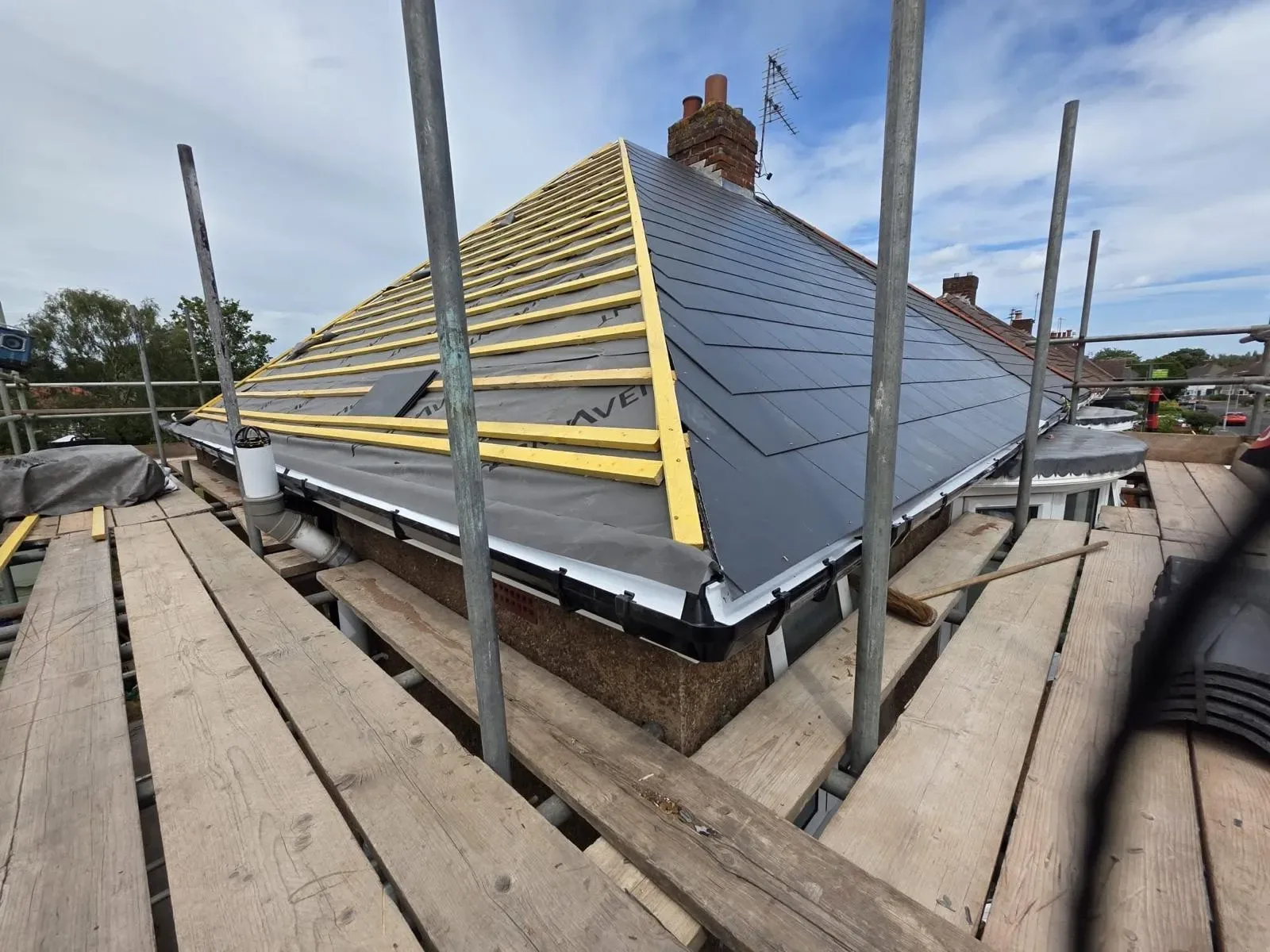 A hipped roof stripped and re-laid in dark concrete tile, image 9