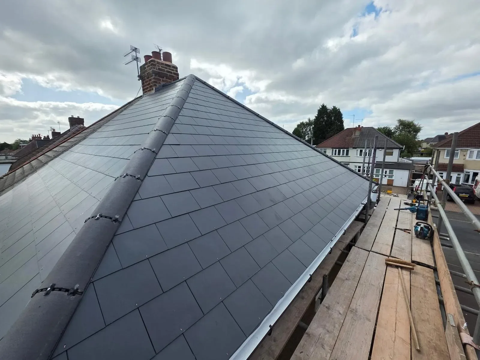 A hipped roof stripped and re-laid in dark concrete tile, image 6