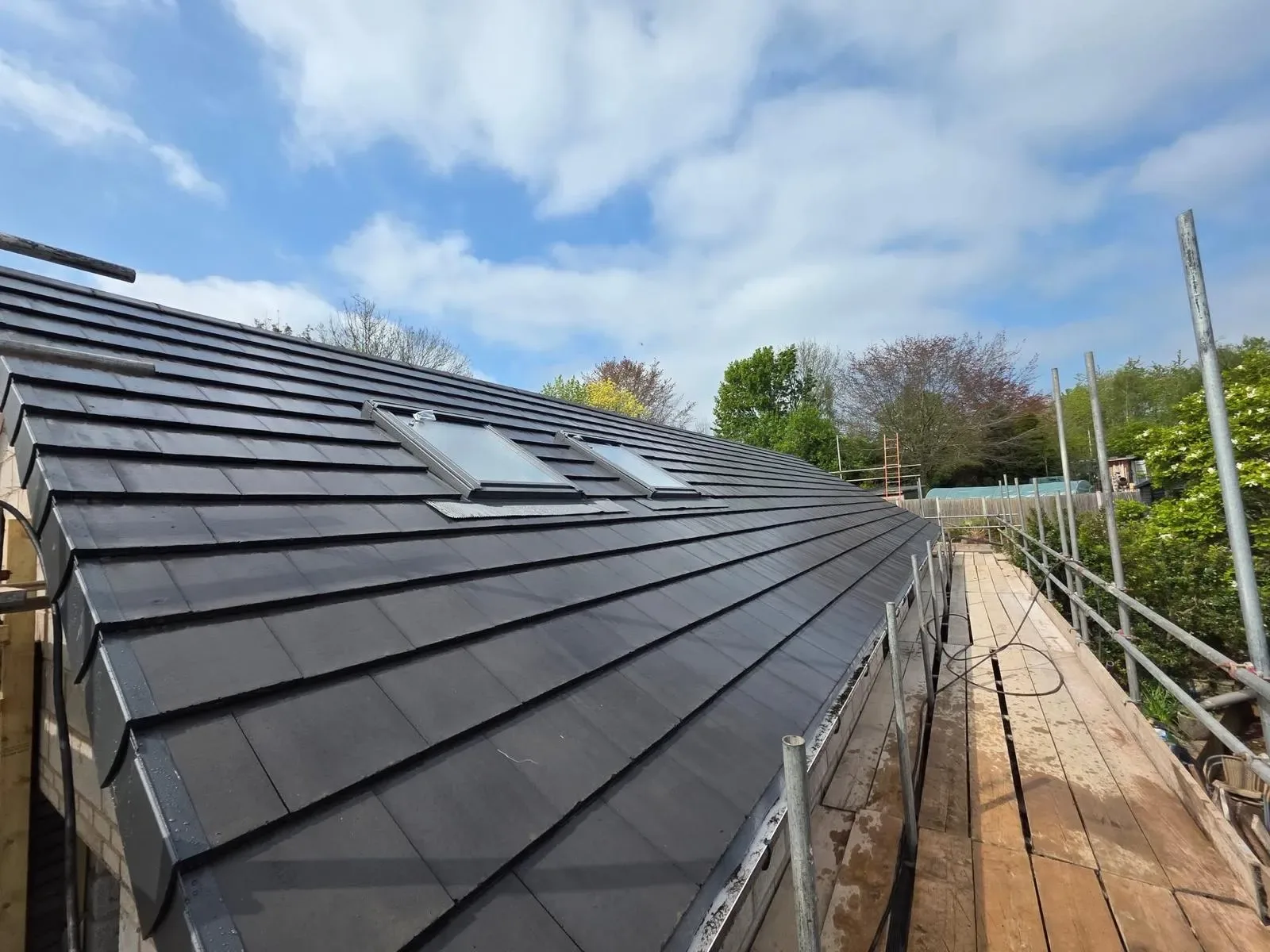 A new build roofed in dark concrete tile, with rooflights