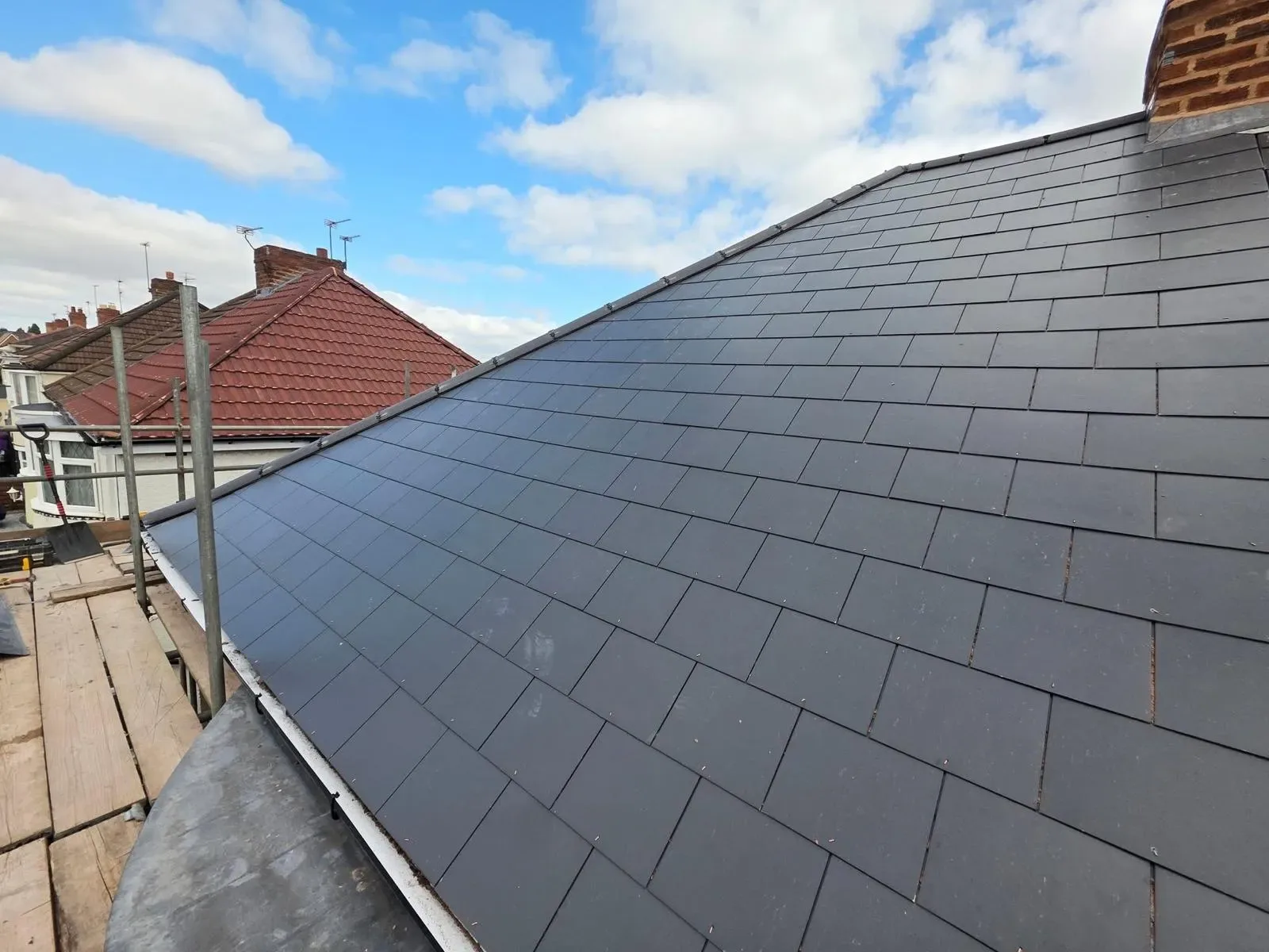 A hipped roof stripped and re-laid in dark concrete tile, image 4