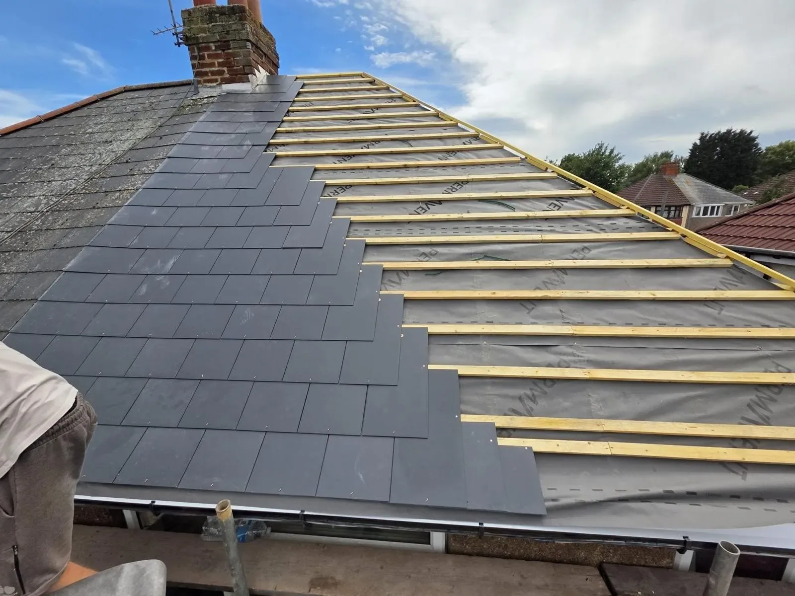 A hipped roof stripped and re-laid in dark concrete tile, image 8