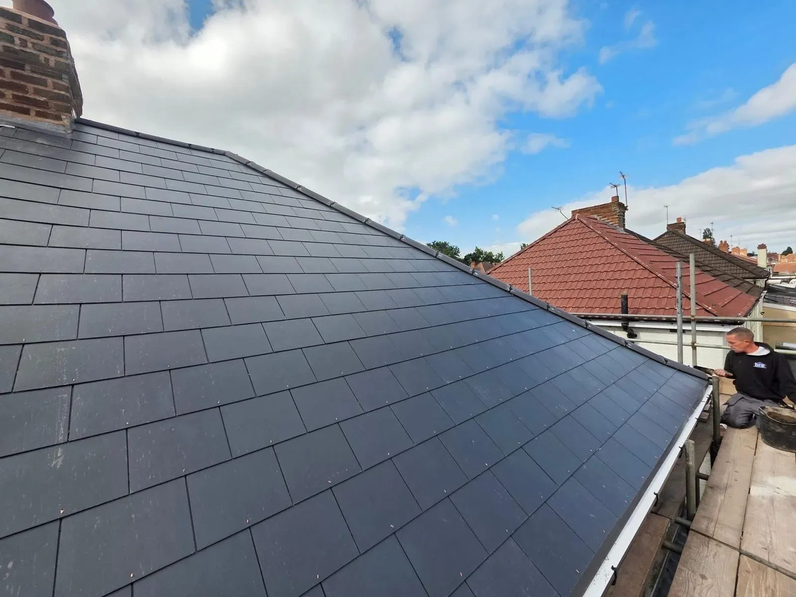 A hipped roof stripped and re-laid in dark concrete tile, image 2