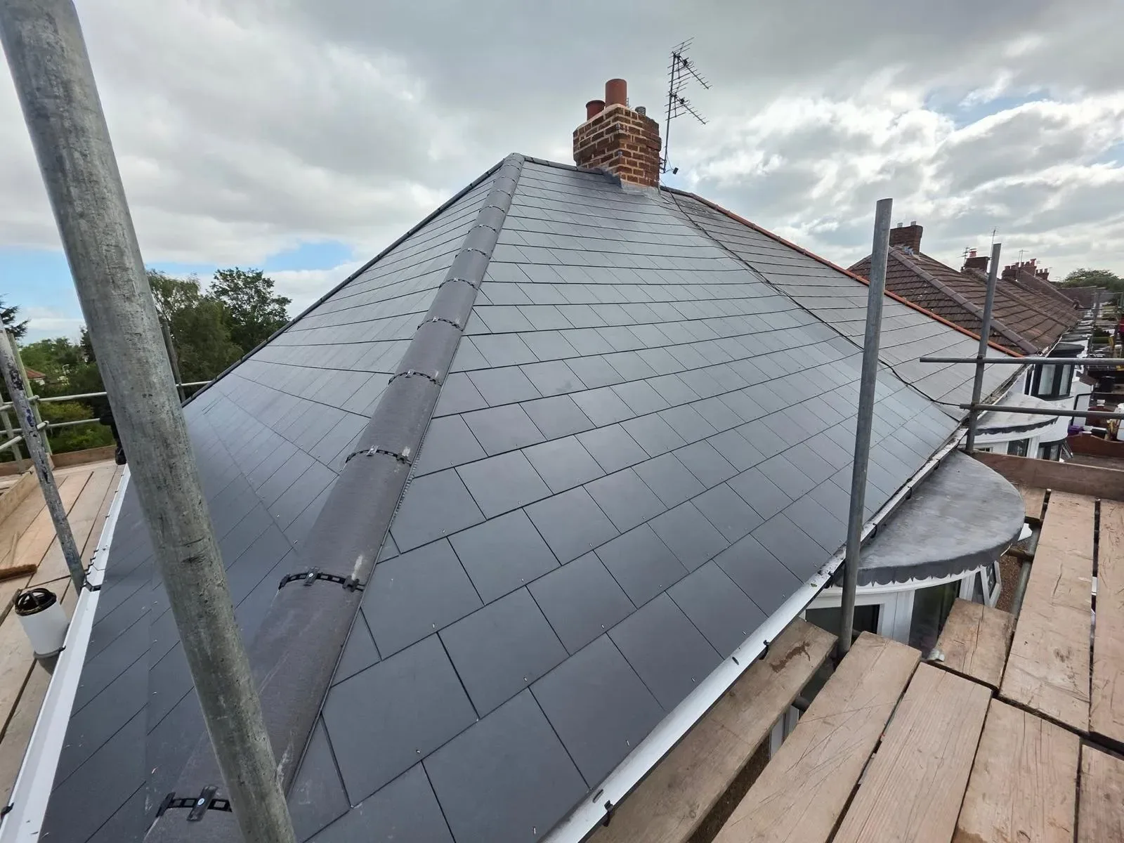 A hipped roof stripped and re-laid in dark concrete tile, image 3