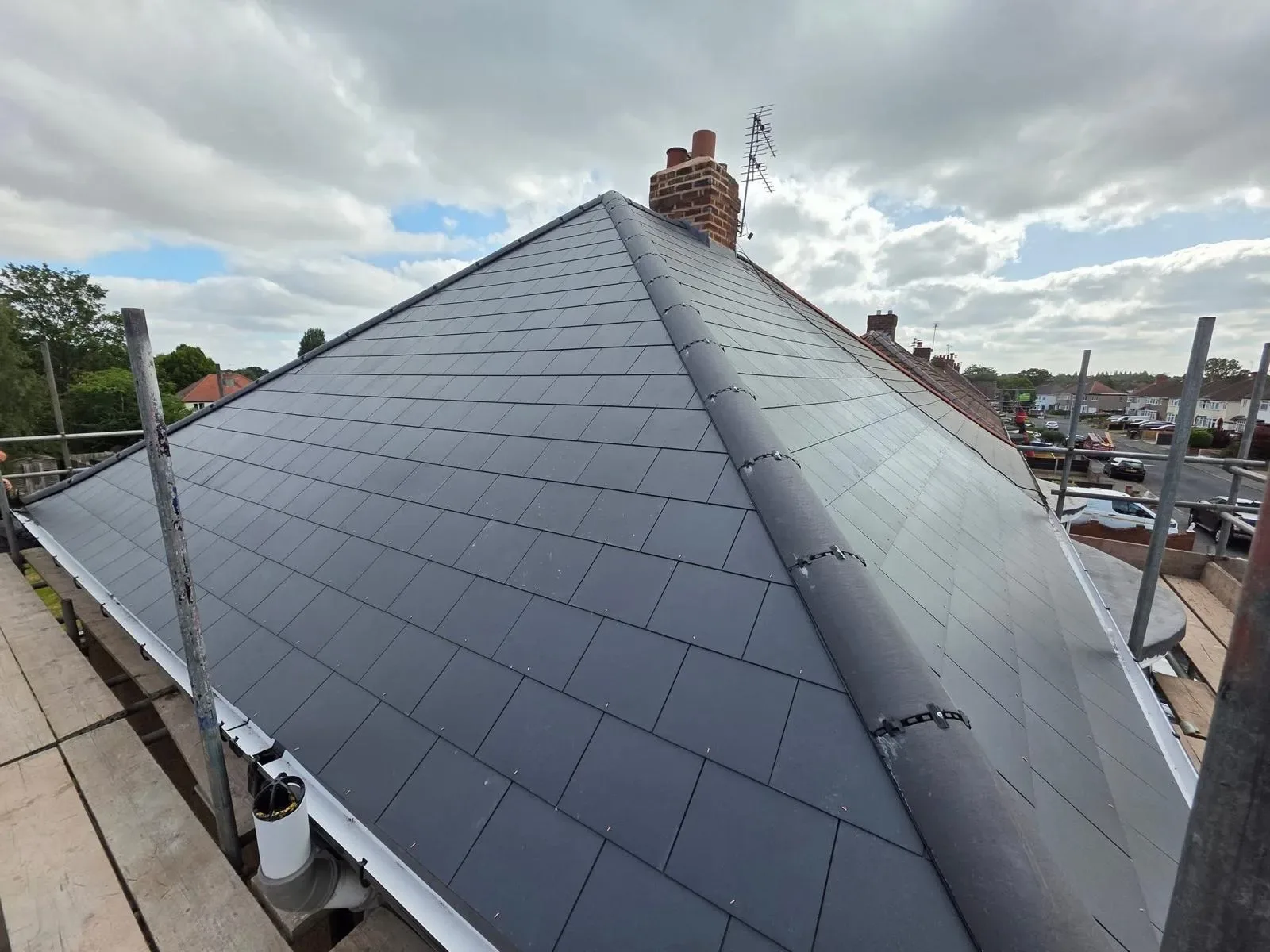 A hipped roof stripped and re-laid in dark concrete tile, image 5