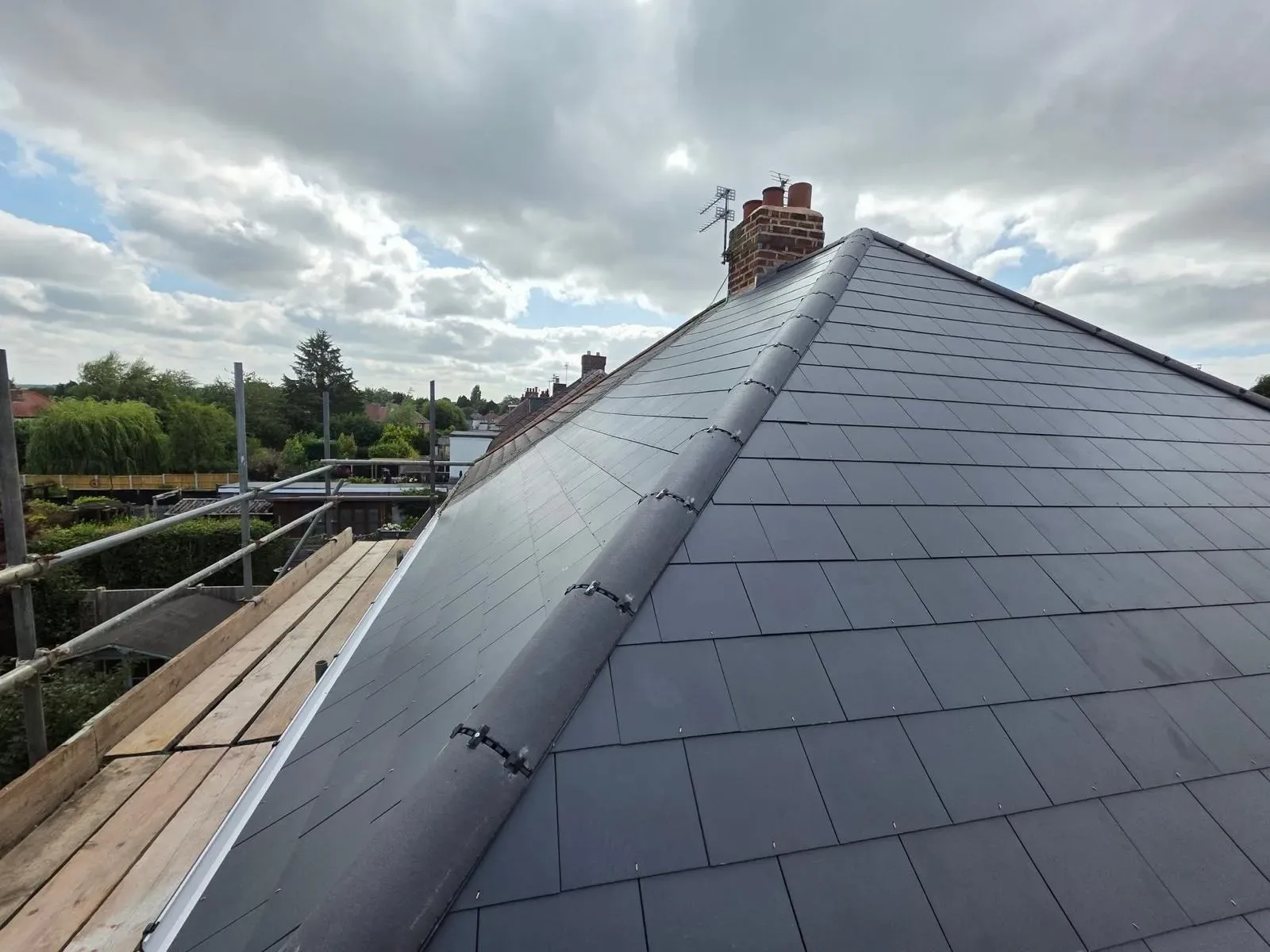 A hipped roof stripped and re-laid in dark concrete tile, image 7